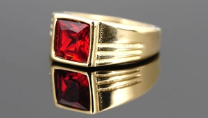 Nahaufnahme von Herrenring in Gold mit quadratischem rotem Edelstein und Streifendetails
