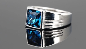 Nahaufnahme eines Herrenrings aus Edelstahl mit großem blauem quadratischem Edelstein