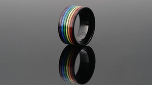 Makroaufnahme schwarzer Edelstahlring mit Regenbogen-Emaille-Streifen und Reflexion