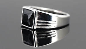 Makro-Detail des Herrenrings aus Edelstahl mit quadratischem schwarzem Edelsteinbesatz
