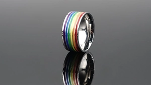Makro-Detail der Regenbogen-Emaille-Streifen auf poliertem Edelstahlring mit Reflexionen