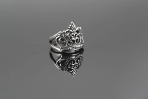 Macro shot of vintage titanium crown ring with intricate hollow floral carvings and textures
