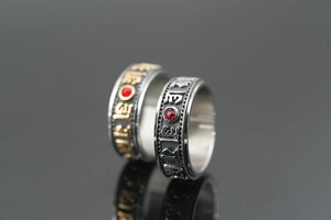 Detailed macro view of rotating titanium steel rings with red stone and mantras