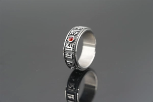 Detail view of rotating stainless steel ring with red zircon and mantra engraving