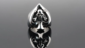 Macro detail of gothic skull and crossbones inside a spade-shaped punk rocker ring