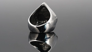 Detail view of a vintage punk skull ring showing the hollow back and metallic texture