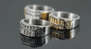 Macro shot of three vintage abacus and coin rings for men in polished silver and gold