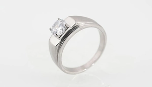 Detalle macro del anillo de plata con cuatro garras que muestra la banda ancha y la gema
