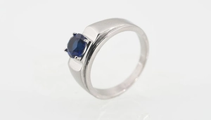 Vista macro detallada del anillo de plata con un zafiro azul oscuro engastado en cuatro garras