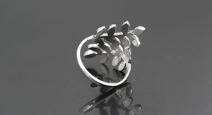 Detailed view of silver leaf pattern ring with polished finish and adjustable opening