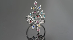 Detailed macro shot of vine leaf ring with multi-color gemstones and beaded edges