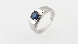 Detalle de engaste de cuatro garras con zafiro azul en banda de plata pulida
