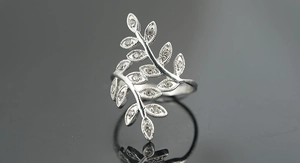 Detailed close-up of olive leaf ring with sparkling crystals and silver beaded edges