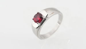 Vista macro de un rubí rojo engastado en plata con diseño clásico de cuatro puntas