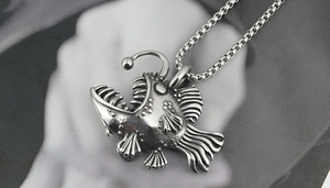 Detailed close-up of retro silver anglerfish pendant with stainless steel box chain