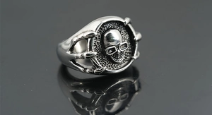 Macro view of gothic skull ring detail with intricate metal claws and brushed texture