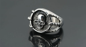 Detail of vintage punk skull ring featuring triple claw design and brushed inner finish