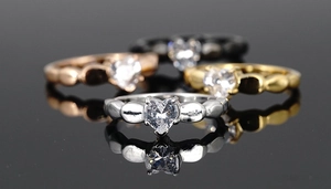 Macro detail of four-claw heart zircon rings in silver gold rose gold and black finish