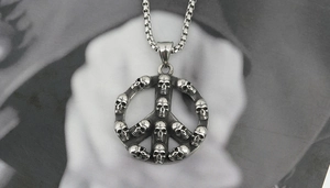 Macro shot of punk style stainless steel skull peace sign pendant with vintage finish