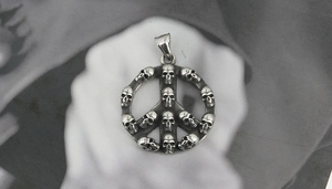 Detailed macro view of vintage gothic peace symbol pendant with 12 miniature skulls