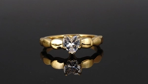 Detailed macro of golden heart-shaped zircon ring with unique beaded texture band