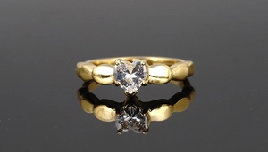 Macro detail of heart-shaped zircon gold titanium ring with four-prong setting