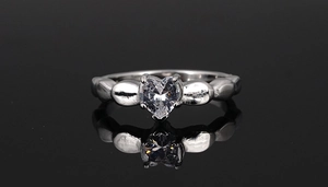 Macro shot of silver titanium ring featuring heart-shaped zirconia and relief patterns