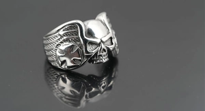 Macro shot of vintage titanium steel skull ring with side cross relief and oxidized finish