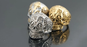 Makroaufnahme von Gothic-Totenkopfringen mit Kreuzgravur und antikem Metall-Finish