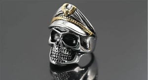 Makroaufnahme eines Vintage-Totenkopfrings mit goldener Marine-Mütze und Punk-Stil