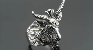 Macro shot of vintage silver goat head ring with pentagram detail and gothic relief