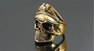 Detailansicht eines Vintage Gold Totenkopf Rings mit Militärkappe auf schwarzem Grund