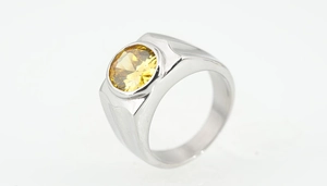 Macro view of titanium steel men's ring featuring a large round yellow zircon in bezel setting