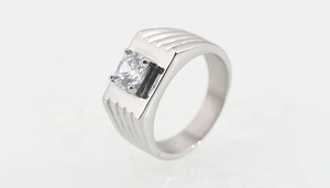 Détail macro d'une bague argentée pour homme avec zircon carré et anneau texturé