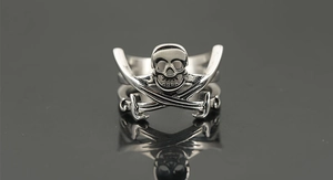Macro detail of gothic pirate skull ring with crossed swords in vintage silver finish