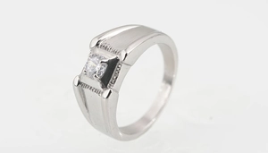 Macro side view of silver titanium steel ring with round zircon and stepped geometric texture