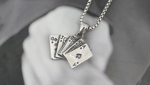 Detailed macro of vintage stainless steel poker card pendant with spades royal flush design