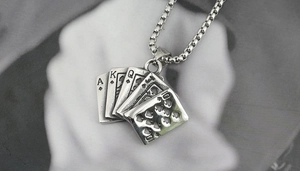 Close-up of vintage spade royal flush poker card pendant on a steel box chain