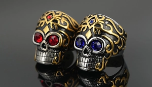 Détails macro de bagues tête de mort gothiques avec strass rouges et bleus et accents dorés