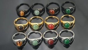 Macro view of vintage round signet rings with tiger eye and agate stones on black surface