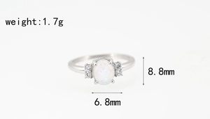 Detalle de anillo de titanio plateado con opalo ovalado y pequeños diamantes laterales