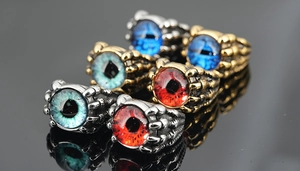 Détail de bagues gothiques avec des yeux réalistes bleus et rouges en griffes métalliques