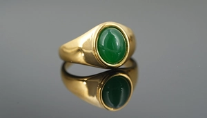 Macro shot of green oval agate signet ring with a polished gold stainless steel band