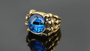 Vue macro d'une bague œil maléfique bleue avec griffes de dragon dorées