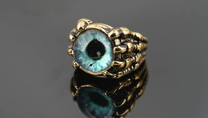 Détail macro d'une bague œil du diable avec un globe oculaire turquoise et griffes
