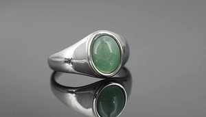 Macro detail of silver titanium steel signet ring with oval green tiger eye stone inlay