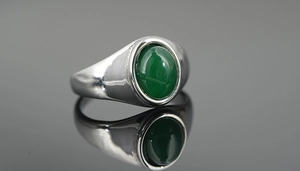 Macro shot of silver titanium ring with deep green oval tiger eye stone inlay