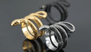 Macro de trois bagues serpent en acier titane avec texture d'écailles en or, argent et noir mat
