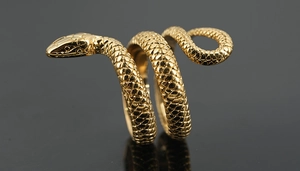 Détail d'une bague serpent dorée en acier titane avec texture d'écailles et fini rétro