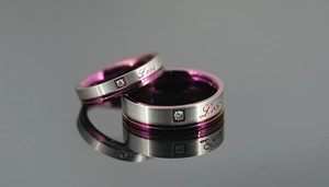 Détail macro d'une bague en titane brossé avec intérieur violet et gravure Love
